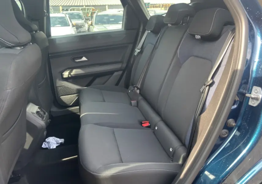 Vue intérieure côté droit sur la banquette arrière noire du Dacia Bigster bleu indigo avec porte ouverte.
