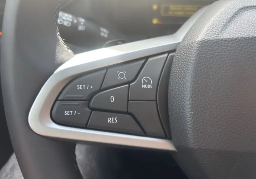 Gros plan sur les commandes de régulateur au volant cuir du Dacia Bigster Hybrid-G 150 4x4 Expression+ 2026.