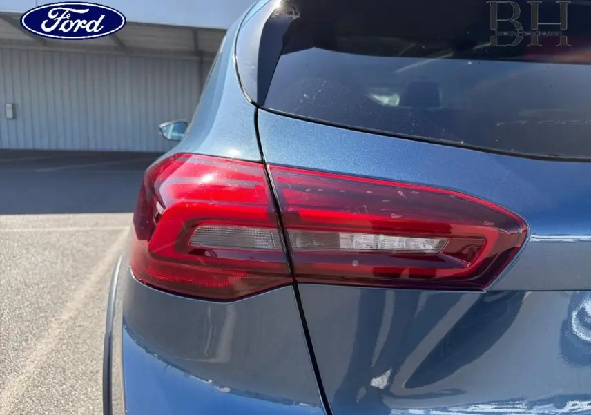 Gros plan sur le feu arrière gauche d'une Ford Focus 2022 bleu azur métallisé, avec carrosserie brillante.