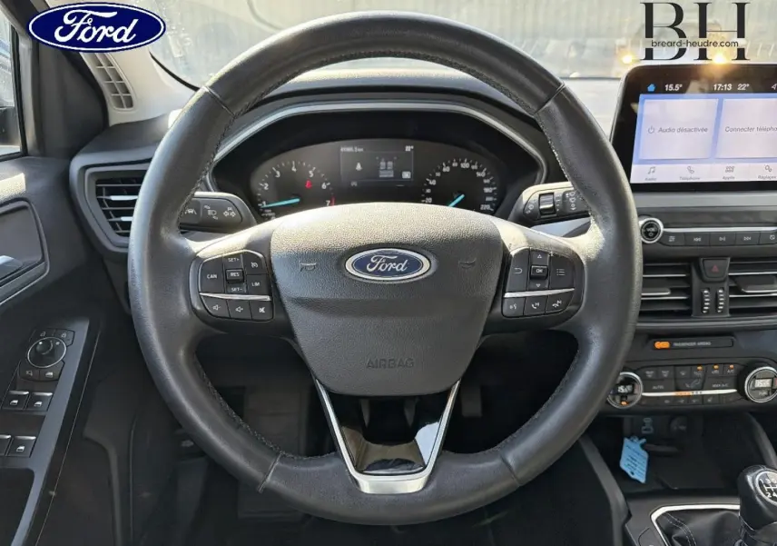 Vue intérieure centrée sur le volant cuir multifonction de la Ford Focus 2022 avec tableau de bord et écran tactile.