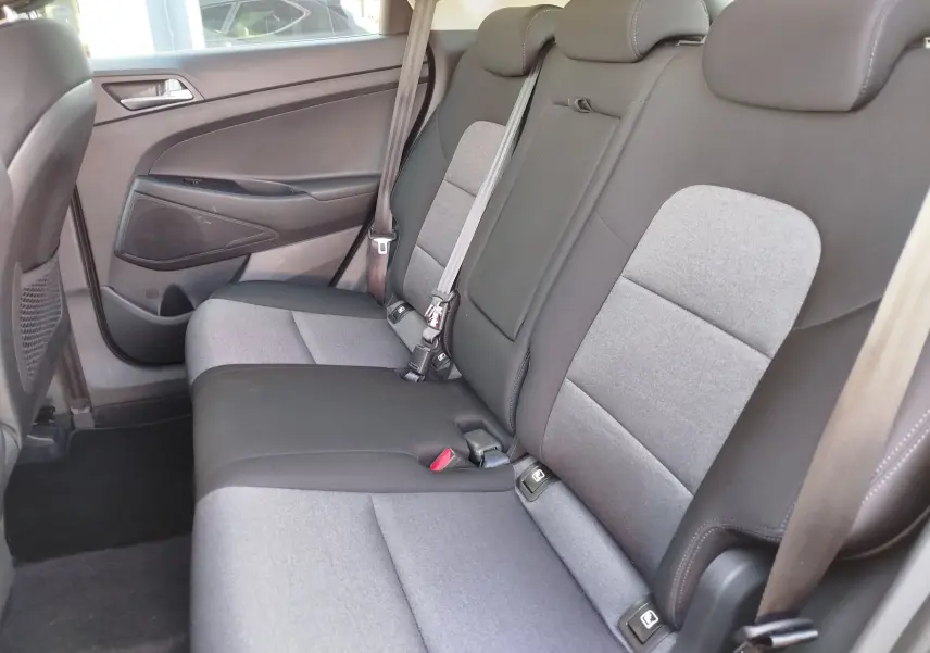 Vue intérieure côté droit des sièges arrière gris clair et noir du Hyundai Tucson 2019 avec ceintures de sécurité visibles.