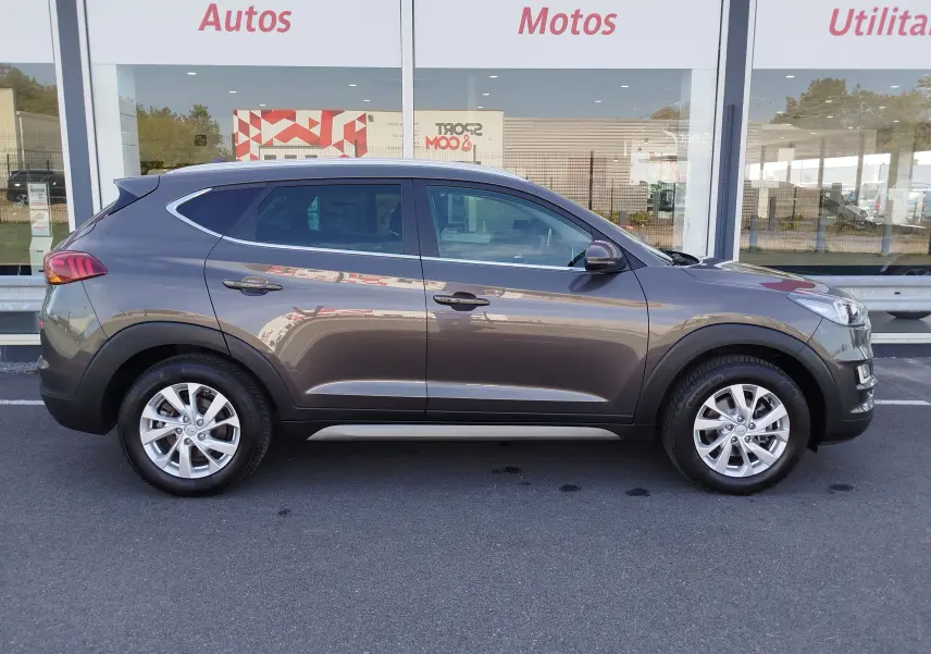 Vue de profil côté gauche d'un Hyundai Tucson gris Micron 2019 avec jantes alliage et carrosserie lisse.