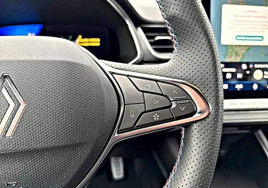 Gros plan sur le volant perforé multifonction de la Renault Symbioz 2026, avec commandes intégrées et coutures tricolores.