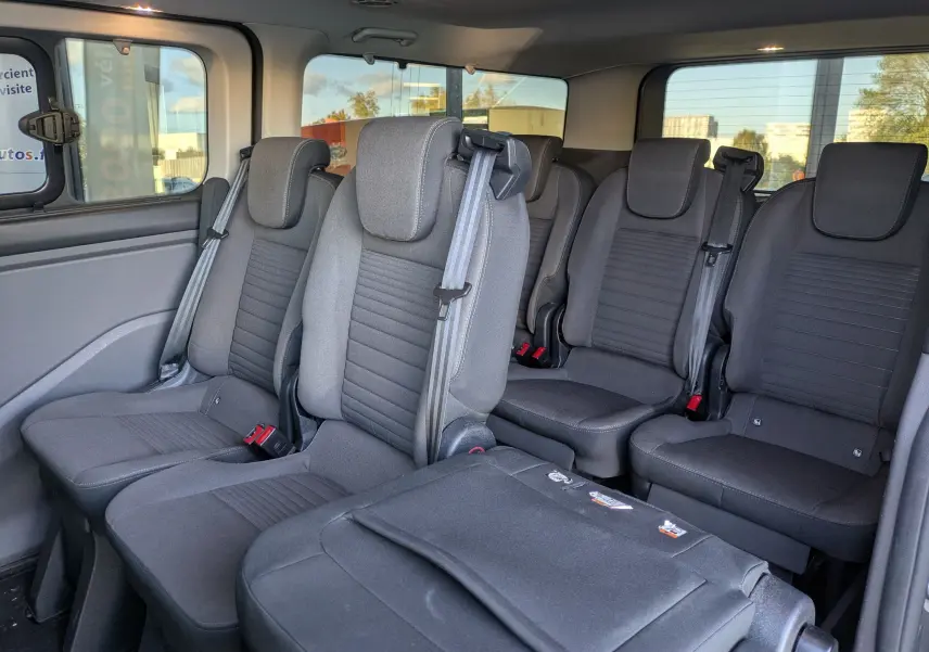 Vue intérieure côté gauche du Ford Tourneo Custom 2019, montrant les sièges gris en tissu pour 8 places.