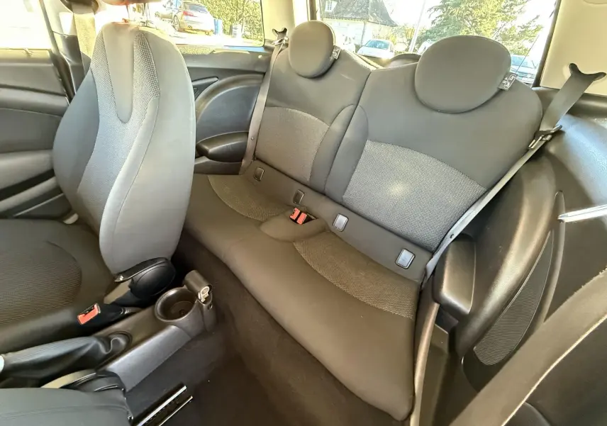 Vue intérieure de la banquette arrière et siège avant gris foncé d'une MINI Cooper 2007, tissu et plastique.