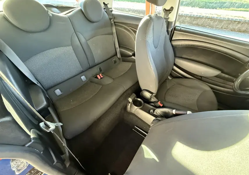 Vue intérieure côté droit de la MINI Cooper 2007 avec sièges tissu gris et console centrale visible.