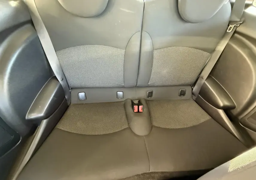 Banquette arrière en tissu gris et noir de la MINI Cooper 1.6 Ess 2007, vue de dessus, avec ceintures de sécurité visibles.