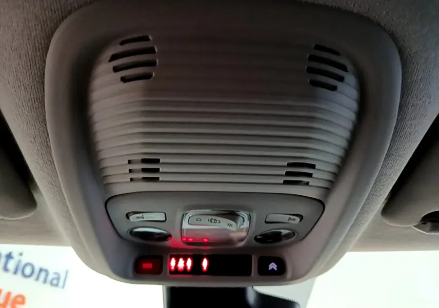 Plafonnier intérieur gris avec commandes d'éclairage et alertes rouges, vue en contre-plongée dans un Citroën C3 Aircross noir.