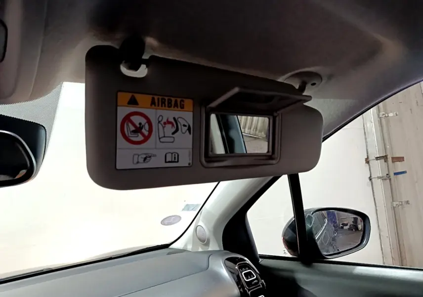 Intérieur de la Citroën C3 Aircross noir, vue côté passager avec pare-soleil et rétroviseur latéral visible.