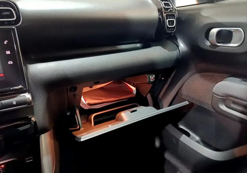Intérieur du Citroën C3 Aircross noir 2019, vue côté passager sur la boîte à gants ouverte et tableau de bord.