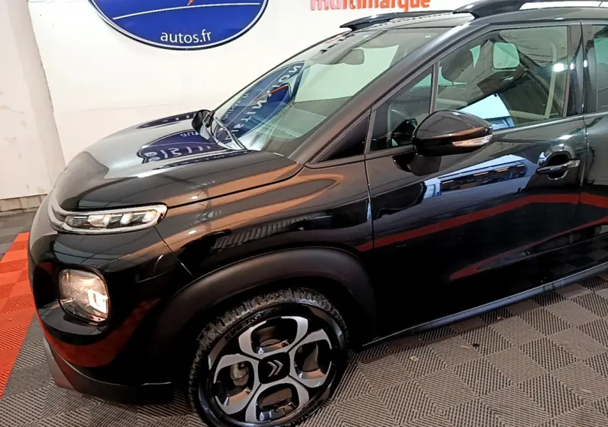 Vue 3/4 avant droit d'un Citroën C3 Aircross noir brillant avec jantes distinctives et rétroviseurs ton caisse.