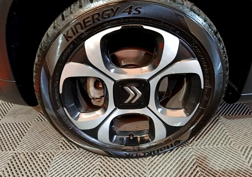 Gros plan sur la jante alliage noire et argentée avec logo Citroën d'un Citroën C3 Aircross noir.