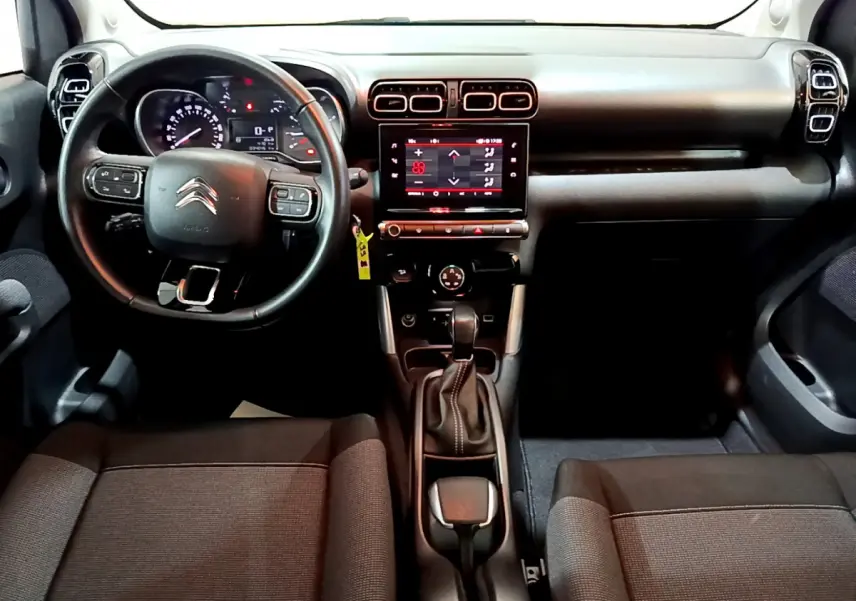 Intérieur du Citroën C3 Aircross 2019 en vue frontale, tableau de bord noir avec écran tactile central et volant multifonctions.