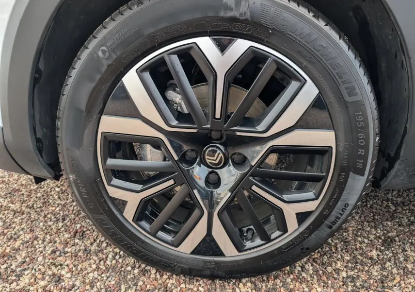 Gros plan sur la jante alliage 18 pouces diamantée noire et argent d'une Citroën C4 blanche, roue avant gauche.