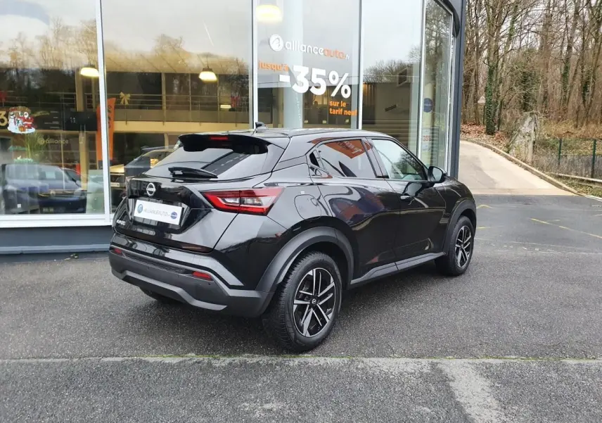 Vue 3/4 arrière droite du Nissan Juke noir métallisé 2025 avec jantes alliage 17'' et antenne aileron de requin.