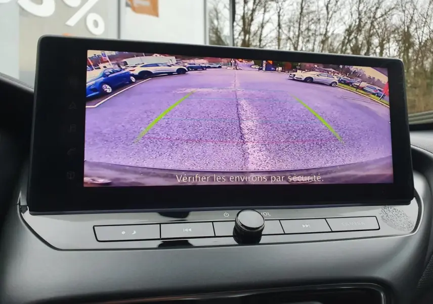 Écran tactile intérieur montrant la caméra de recul du Nissan Juke noir, avec lignes d'aide au stationnement visibles.