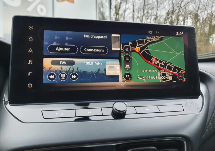 Écran tactile 12,3'' du Nissan Juke 2025 affichant navigation et radio, vue rapprochée du tableau de bord intérieur.