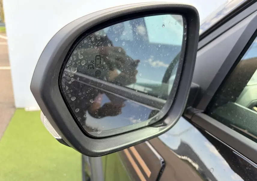 Rétroviseur extérieur côté gauche du Dacia Bigster noir nacré avec détection des angles morts visible.