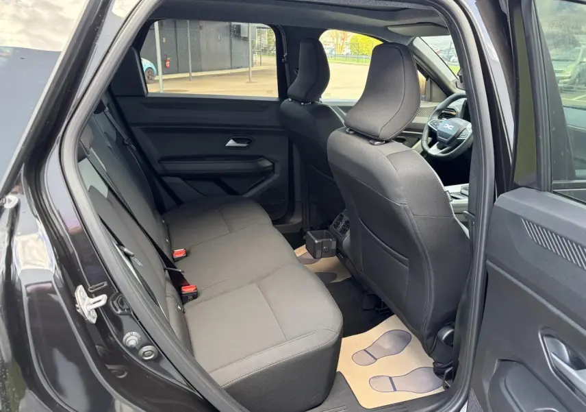 Vue intérieure côté gauche montrant la banquette arrière noire et les sièges avant du Dacia Bigster 2025.