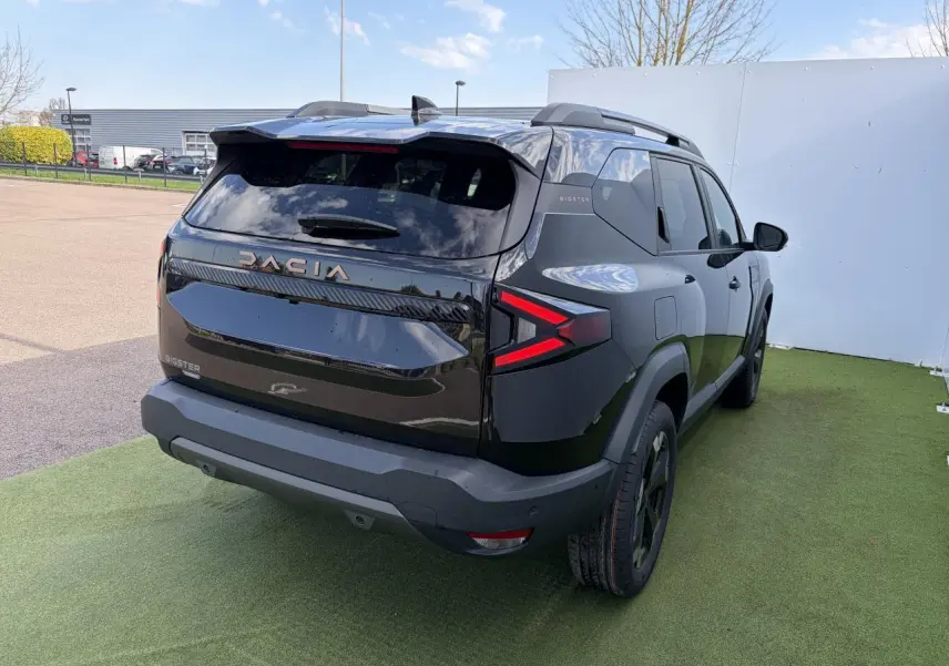 Vue 3/4 arrière droite du Dacia Bigster noir nacré 2025 avec feux arrière LED et toit ouvrant panoramique visible.