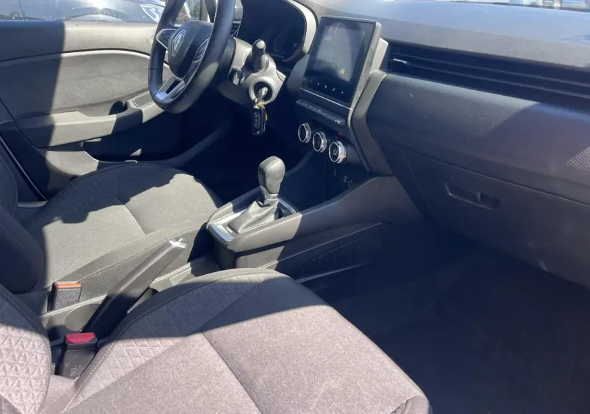 Intérieur avant droit de la Renault Clio blanc Quartz 2021, montrant sièges noirs et console centrale avec écran tactile.