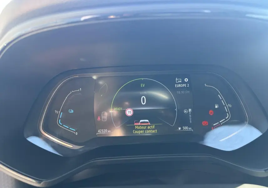Tableau de bord numérique de Renault Clio 1.6 E-Tech blanc, affichant vitesse zéro et alertes moteur actives.