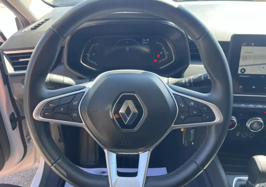 Vue intérieure centrée sur le volant noir de la Renault Clio 1.6 E-Tech 2021 avec tableau de bord digital et écran tactile.