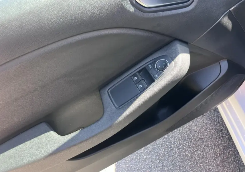 Gros plan sur la porte avant gauche noire de la Renault Clio 1.6 E-Tech 140ch Business, avec commandes électriques.