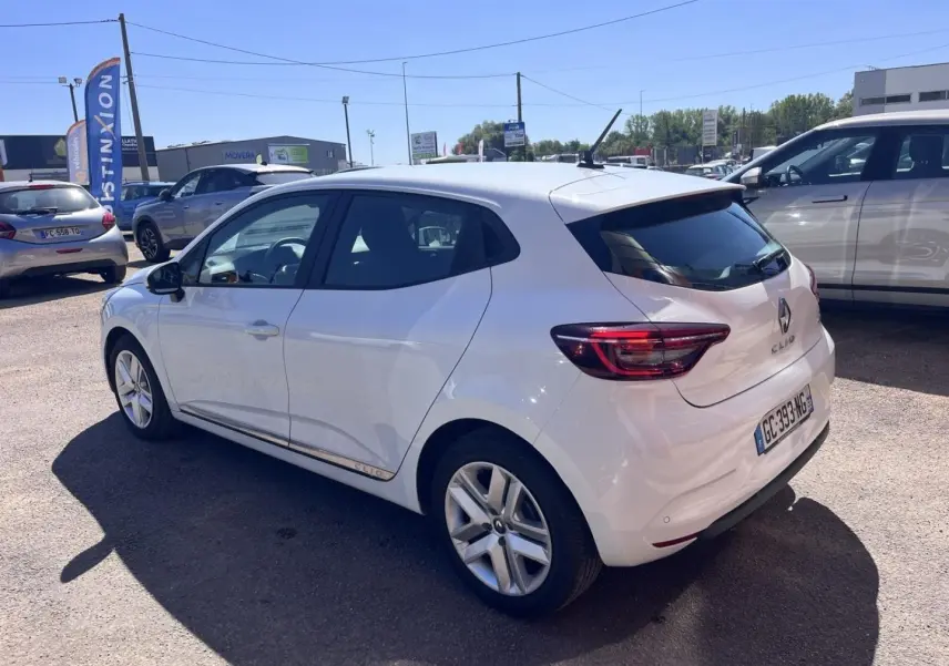 Renault Clio blanc Quartz vue 3/4 arrière droit, avec feux LED et jantes alliage visibles.
