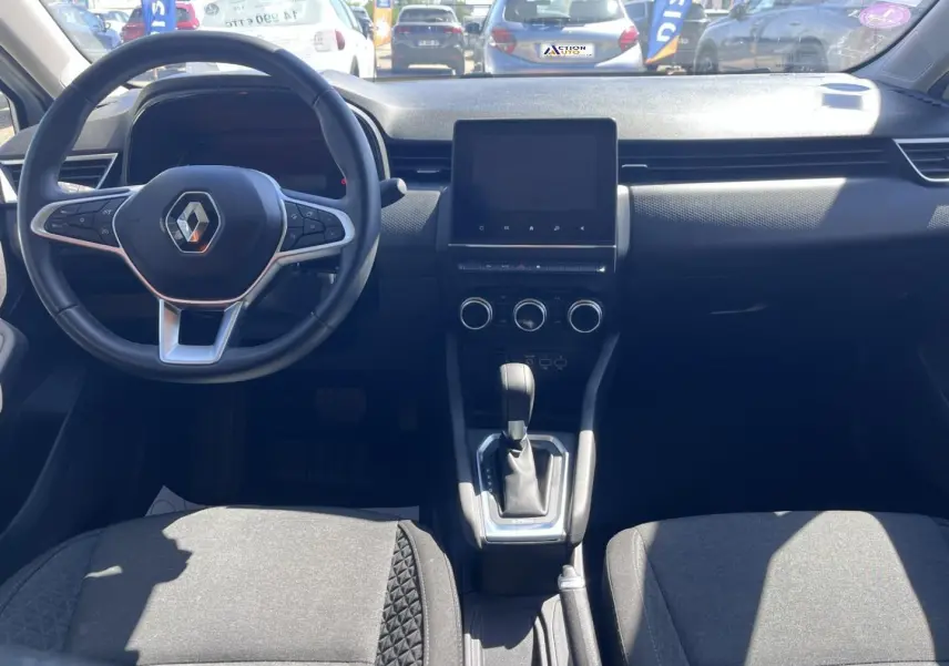 Vue intérieure avant de la Renault Clio 1.6 E-Tech 2021, tableau de bord noir avec écran tactile et volant multifonction.