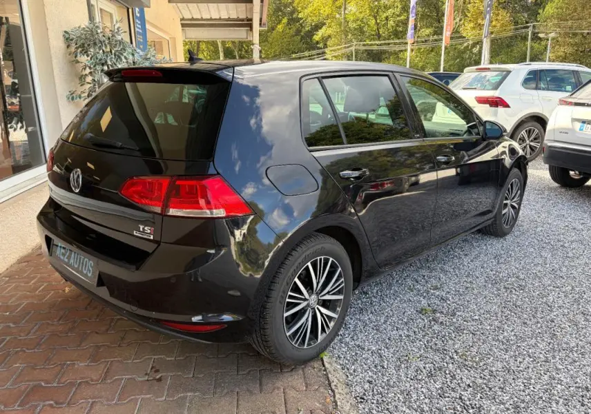 Vue 3/4 arrière droite d'une Volkswagen Golf 7 noire, avec jantes alliage et rétroviseurs électriques rabattables.