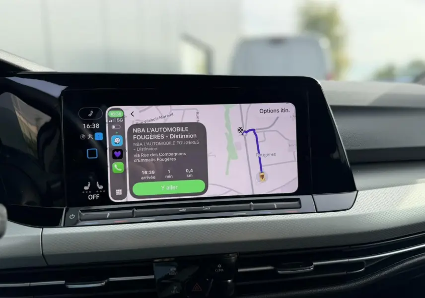 Vue rapprochée de l'écran tactile central de la Volkswagen Golf 8 gris lunaire, affichant la navigation GPS.