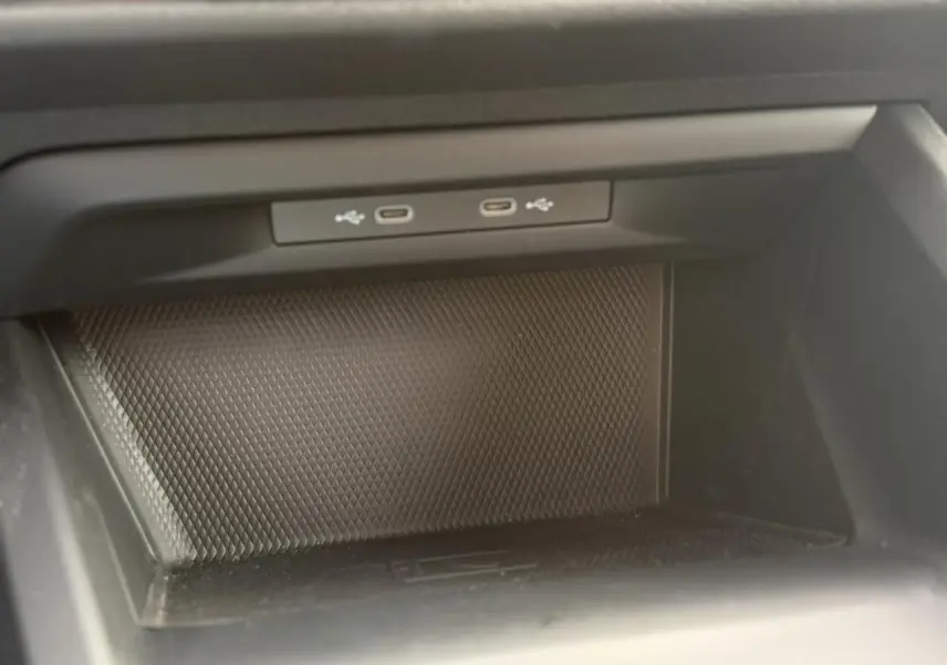 Gros plan sur la console centrale de la Volkswagen Golf 8 gris lunaire, montrant deux ports USB-C intégrés.
