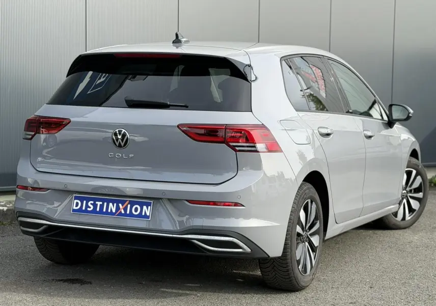 Volkswagen Golf 8 gris lunaire vue 3/4 arrière droit, feux LED et jantes alliage distinctives.