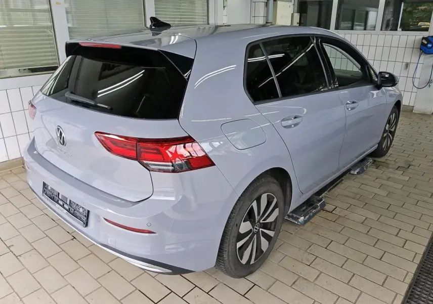 Vue 3/4 arrière droit d'une Volkswagen Golf 8 gris lunaire avec feux arrière LED et jantes alliage Norfolk.