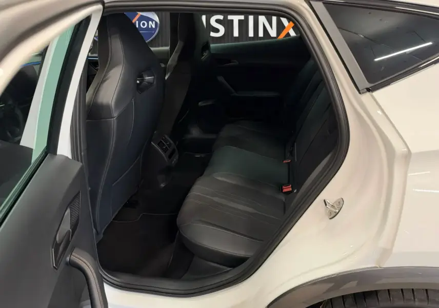 Vue intérieure côté gauche montrant la banquette arrière en cuir noir du CUPRA Formentor blanc 2024, porte ouverte.