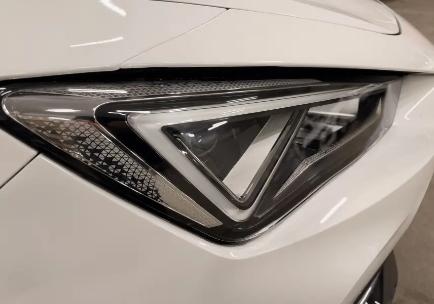 Gros plan sur le phare avant droit blanc du CUPRA Formentor 1.4 E-HYBRID 245 CH VZ DSG6 2024, design triangulaire distinctif.