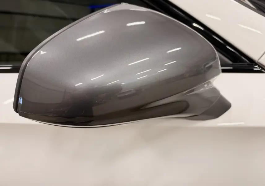 Rétroviseur latéral droit gris métallisé sur CUPRA Formentor blanc 2024, avec carrosserie brillante visible en arrière-plan.