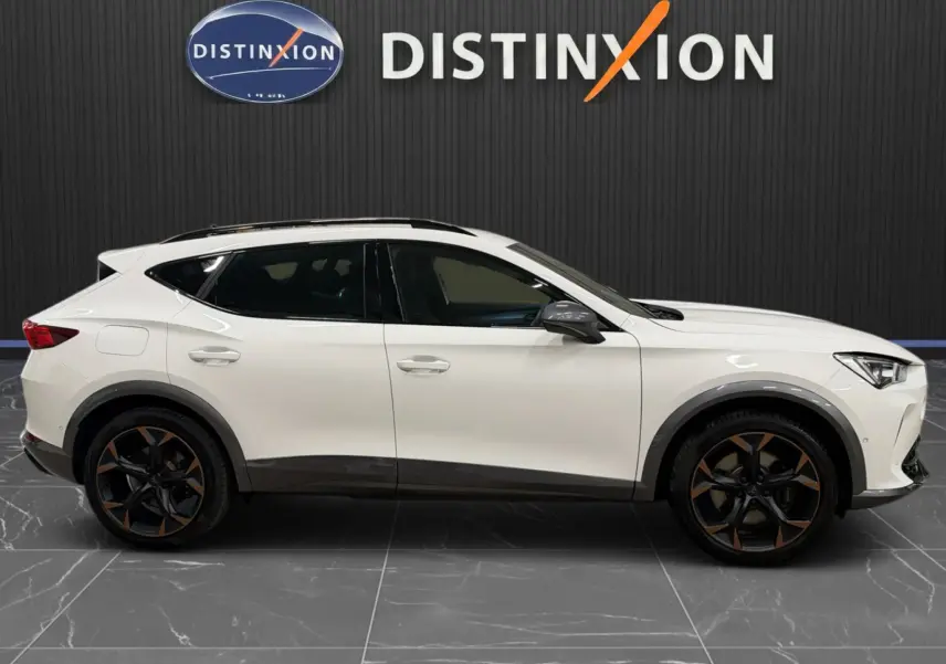 Vue latérale droite d'un CUPRA Formentor blanc 2024 avec jantes noires et bronze, toit ouvrant et vitres teintées.