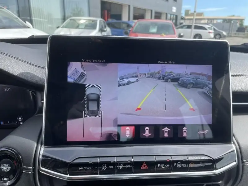 Écran central du Jeep Compass 2024 blanc montrant la caméra de recul et la vue à 360 degrés du stationnement.