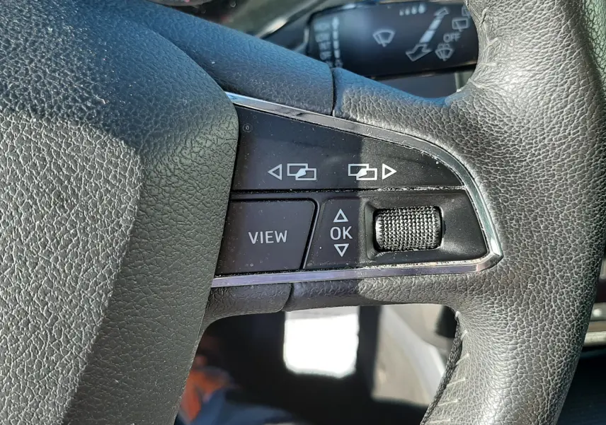 Gros plan sur les commandes à gauche du volant en cuir noir du SEAT Arona gris Magnetic 2019.