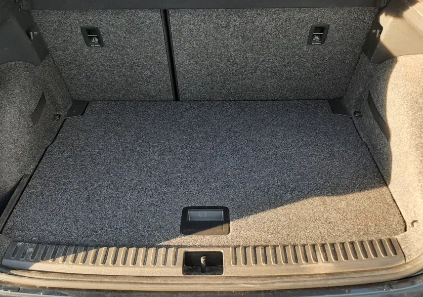 Coffre ouvert vu de l'arrière d'un SEAT Arona gris Magnetic avec toit noir, montrant l'espace de chargement vide.