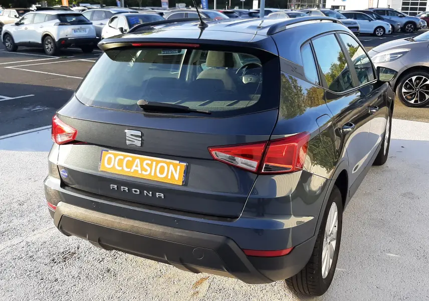 SEAT Arona gris Magnetic avec toit noir, vue 3/4 arrière droit, stationné en extérieur sur parking.