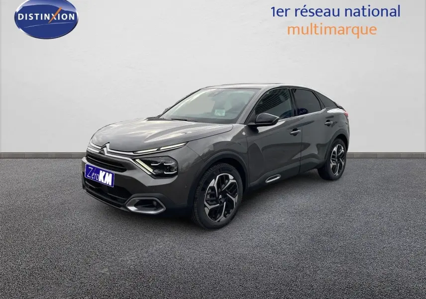 Citroën C4 2024 gris platinium métal en 3/4 avant droit, avec jantes biton et lignes modernes distinctives.
