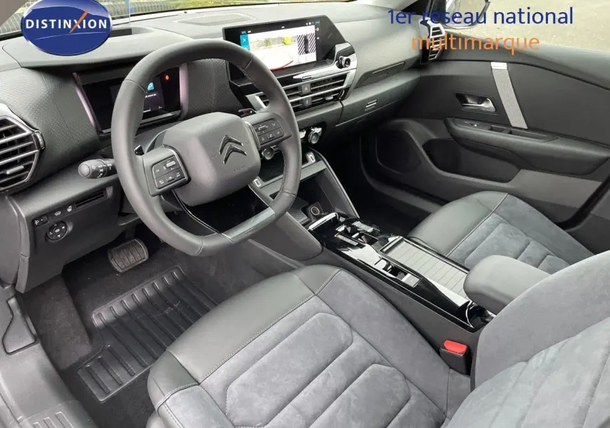 Intérieur moderne de la Citroën C4 2024, vue côté conducteur, sièges en cuir noir et alcantara gris, tableau de bord avec écran tactile.