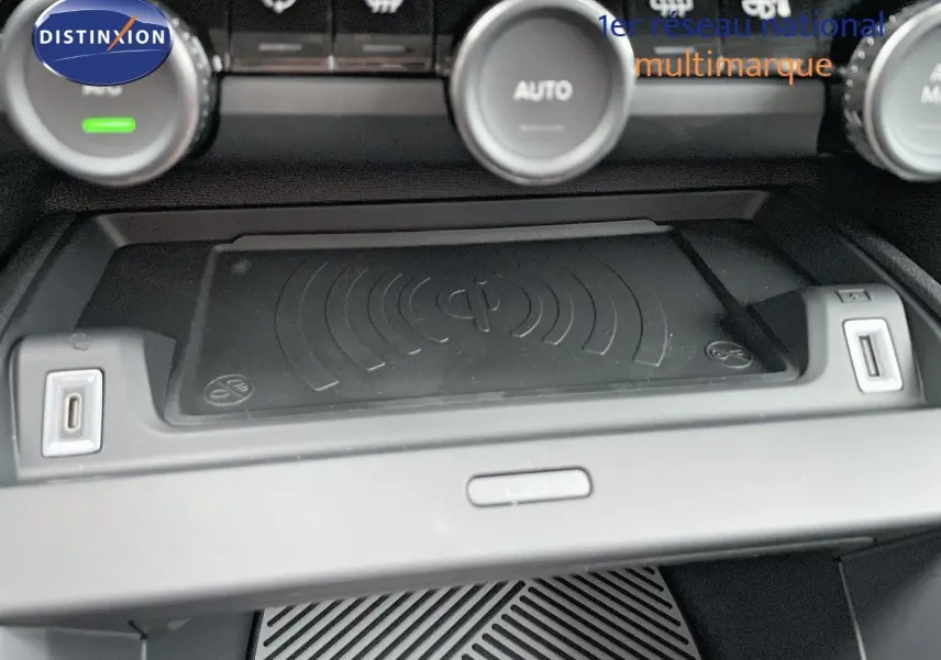 Gros plan sur la console centrale de la Citroën C4 2024, avec plateau de recharge sans fil et ports USB visibles.