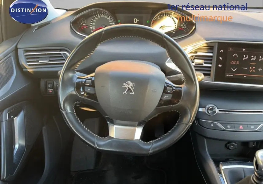 Vue intérieure centrée sur le volant cuir noir du Peugeot 308 SW 2019 avec tableau de bord et écran tactile.