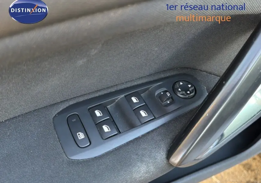 Gros plan sur les commandes des vitres électriques côté conducteur du Peugeot 308 SW gris Artense Metal de 2019.