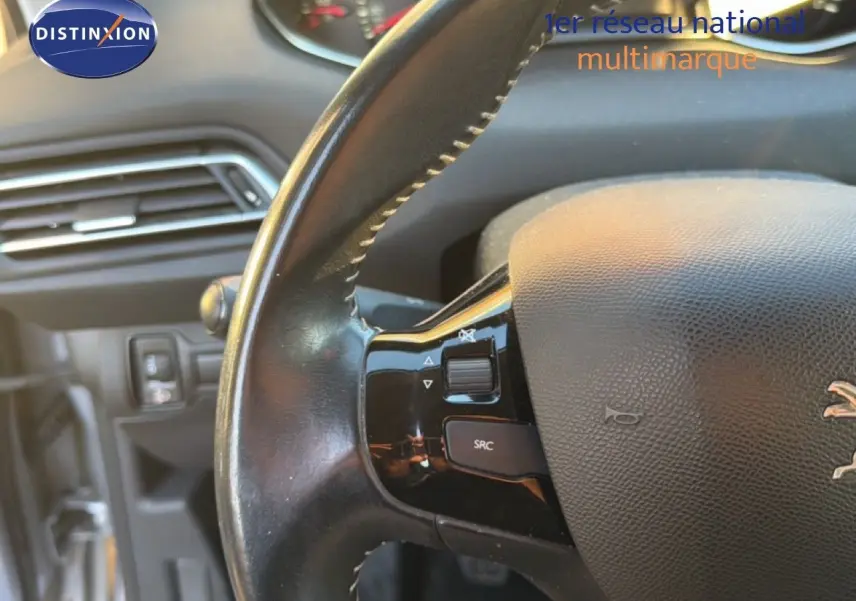 Gros plan sur le volant en cuir noir avec commandes intégrées du Peugeot 308 SW gris Artense Metal de 2019.