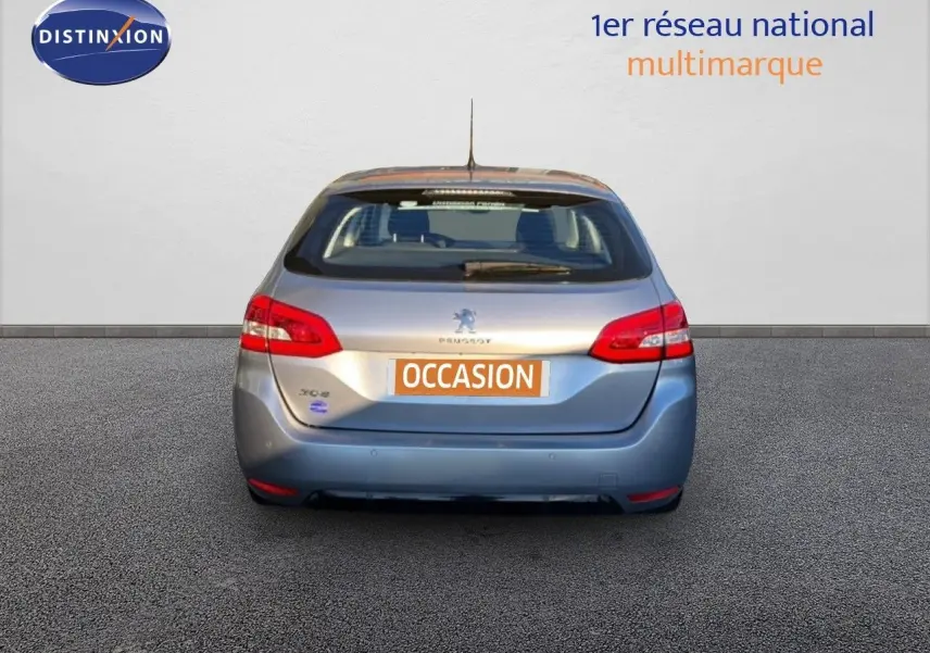 Vue arrière d'une Peugeot 308 SW gris Artense métal de 2019 avec feux rouges et plaque "OCCASION" visible.